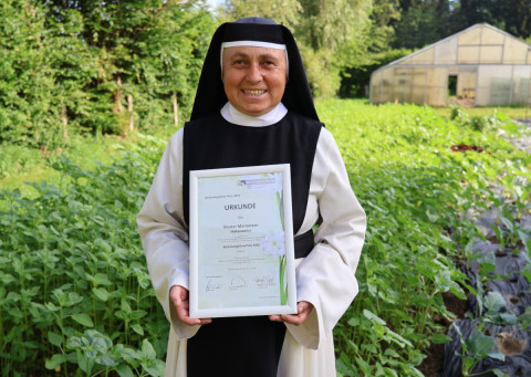 Sr. Cordula mit der Urkunde der Bodenseeg&auml;rten